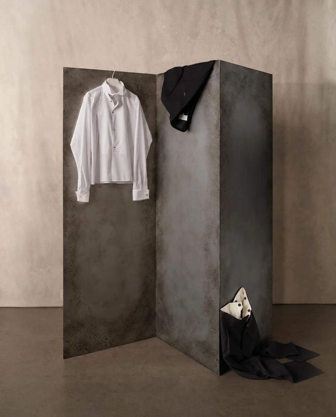 A white shirt and black tailoring on a folding steel screen